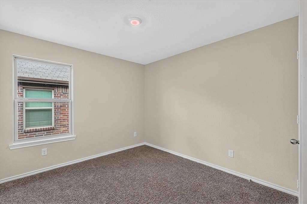 114 Real Quiet Lane, Caddo Mills, TX 75135 Neutral-toned interior room featuring wall-to-wall carpeting, a single-hung window, and a flush-mount ceiling light fixture