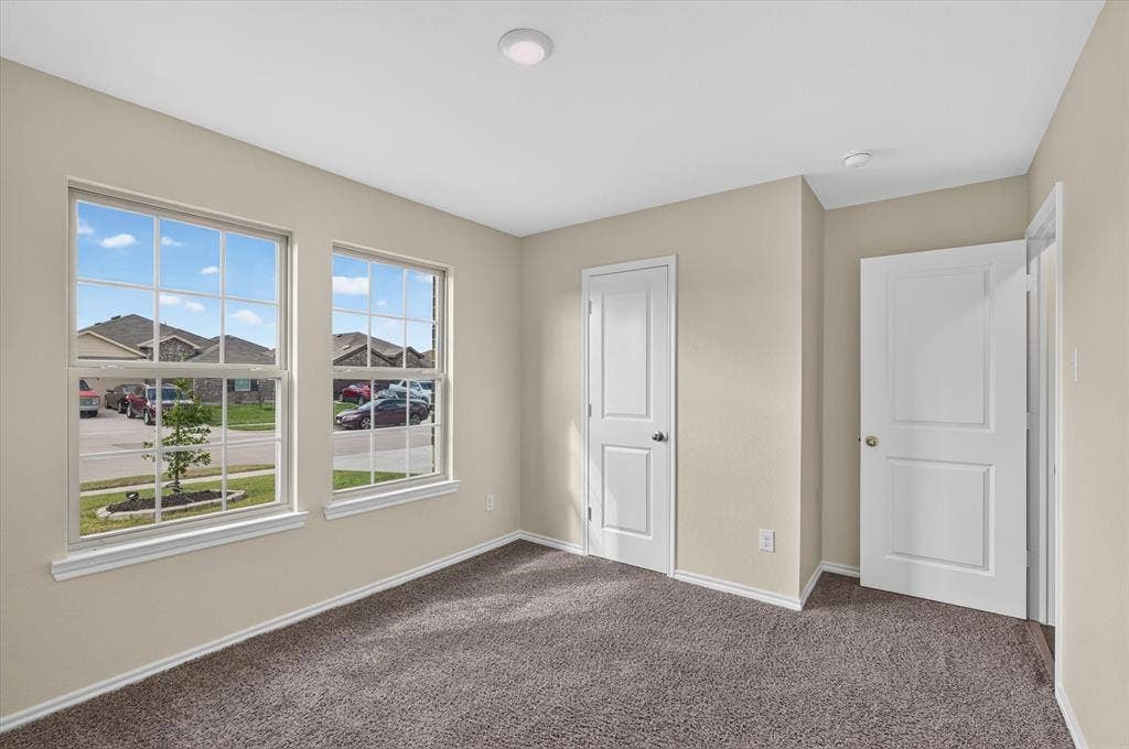 114 Real Quiet Lane, Caddo Mills, TX 75135 Neutral-toned interior space featuring dual grid-pattern windows, recessed lighting, wall-to-wall carpeting, and two paneled interior doors