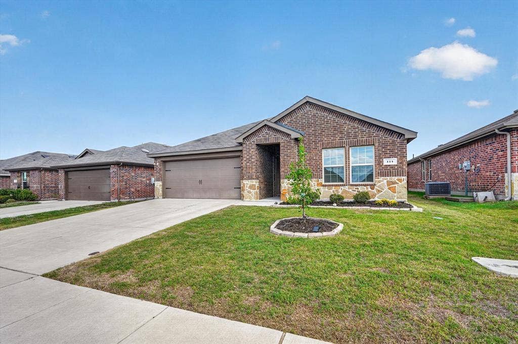 114 Real Quiet Lane, Caddo Mills, TX 75135 Brick and stone veneer facade featuring a double-car garage, concrete driveway, and mulched landscaping beds