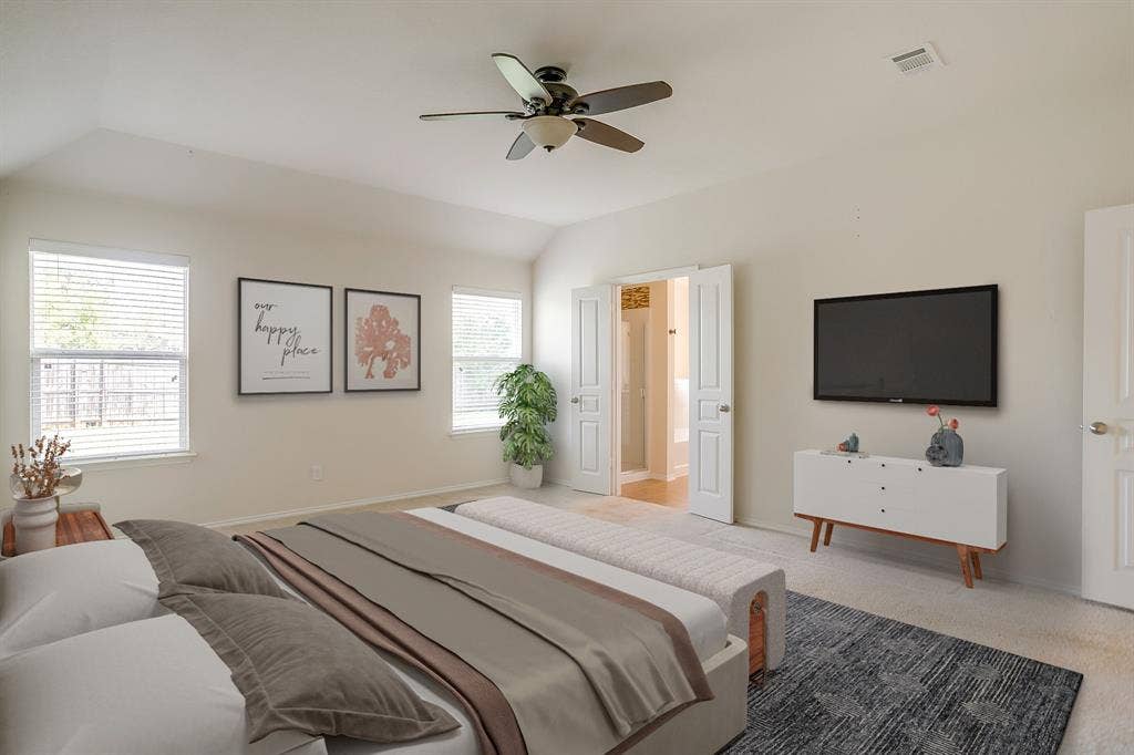 Vaulted ceilings, neutral wall tones, carpeted flooring, double-door entryway, and ceiling fan with integrated light fixture