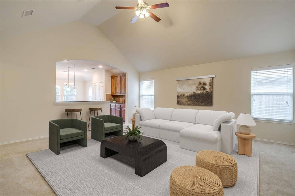 Vaulted ceilings, arched wall opening, recessed lighting, ceiling fan, and windows with horizontal blinds