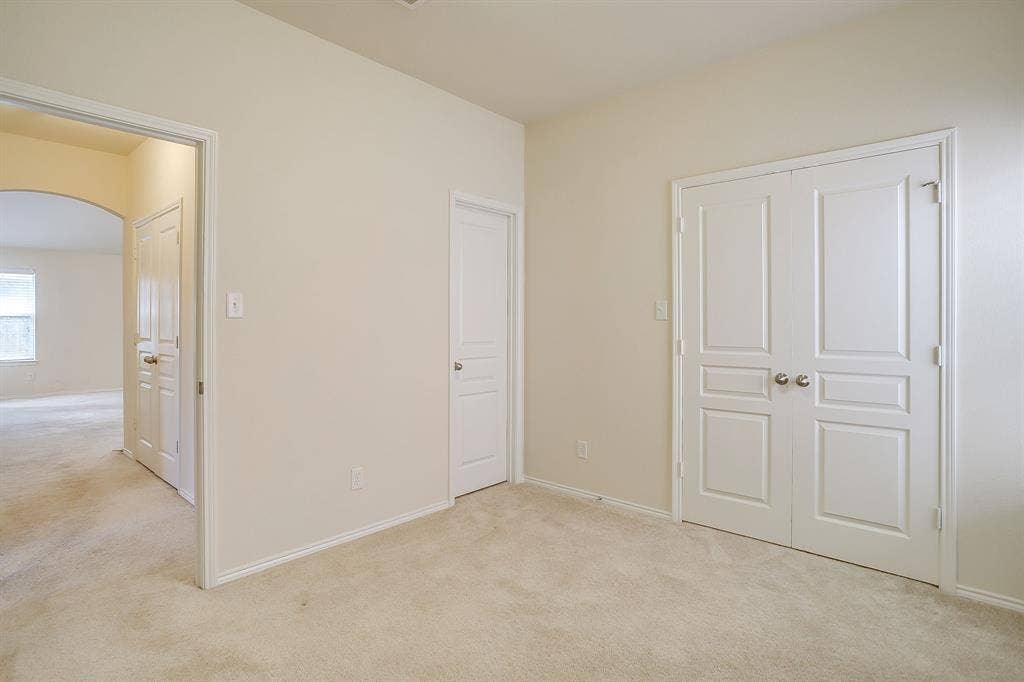 Neutral-toned carpeting, two-panel interior doors, and double-door closet entry