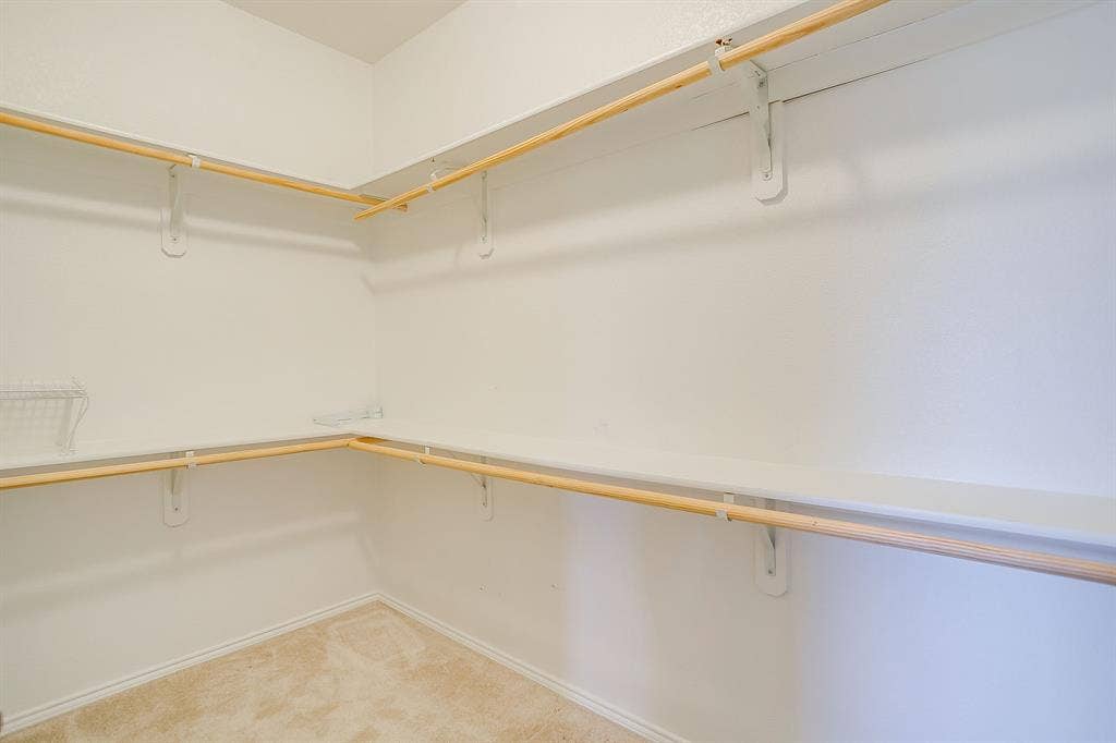 Storage area featuring dual-level hanging rods and integrated shelving units