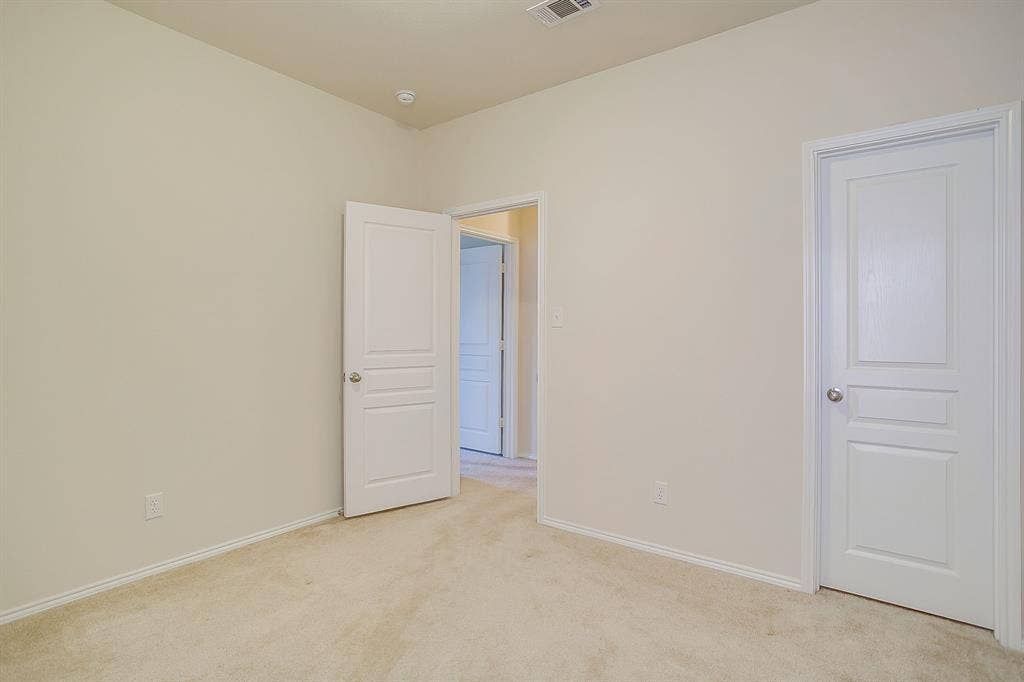 Neutral-toned interior featuring plush carpeting and multi-panel solid-core doors with satin nickel hardware