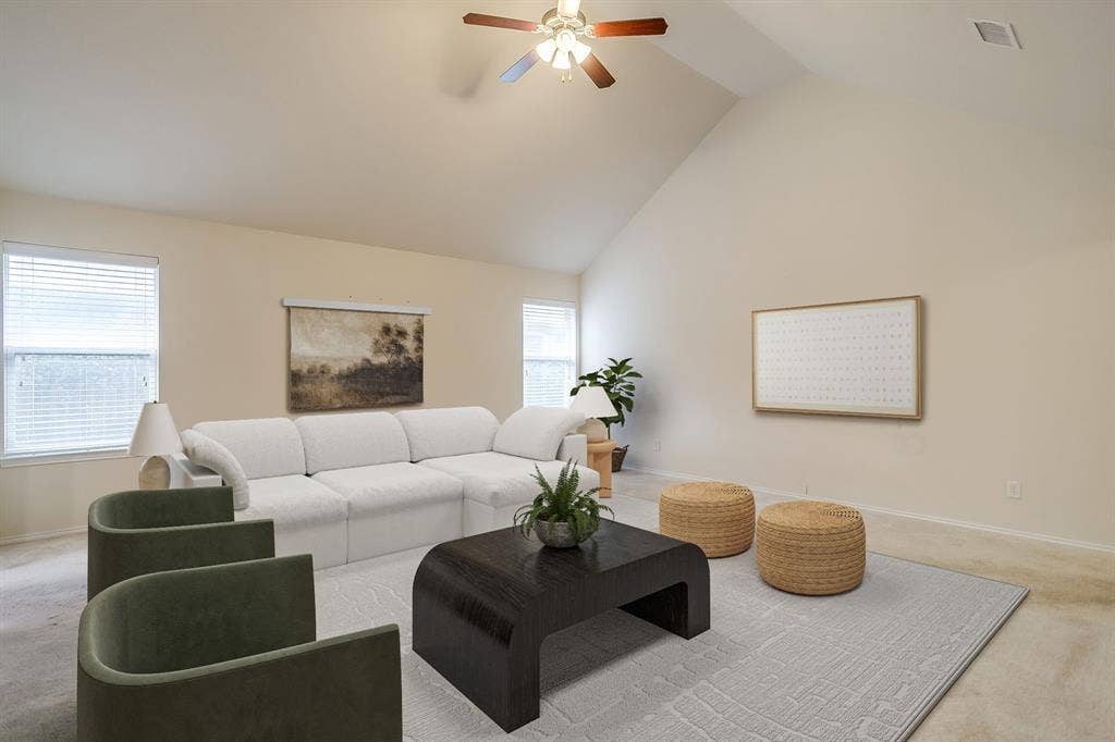 Vaulted ceilings, neutral wall finishes, carpeted flooring, and a ceiling fan with integrated lighting