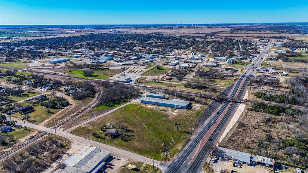 110 1st Street, McGregor, TX 76657 Aerial perspective featuring open land parcel, proximity to major thoroughfare, and access to rail infrastructure