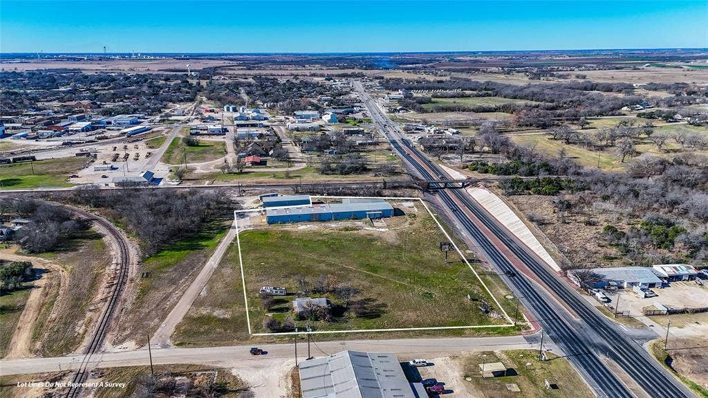 110 1st Street, McGregor, TX 76657 Expansive parcel featuring prominent highway frontage, multiple metal-clad structures, open land, and rail accessibility
