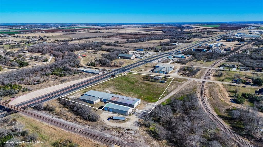 110 1st Street, McGregor, TX 76657 Expansive parcel featuring multi-building industrial structures, metal roofing, paved exterior surfacing, and direct highway frontage