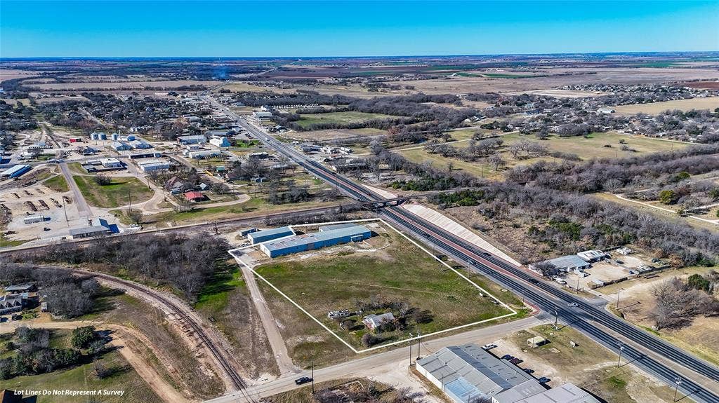 110 1st Street, McGregor, TX 76657 Expansive lot featuring direct highway frontage, cleared terrain, and multiple industrial-style metal buildings
