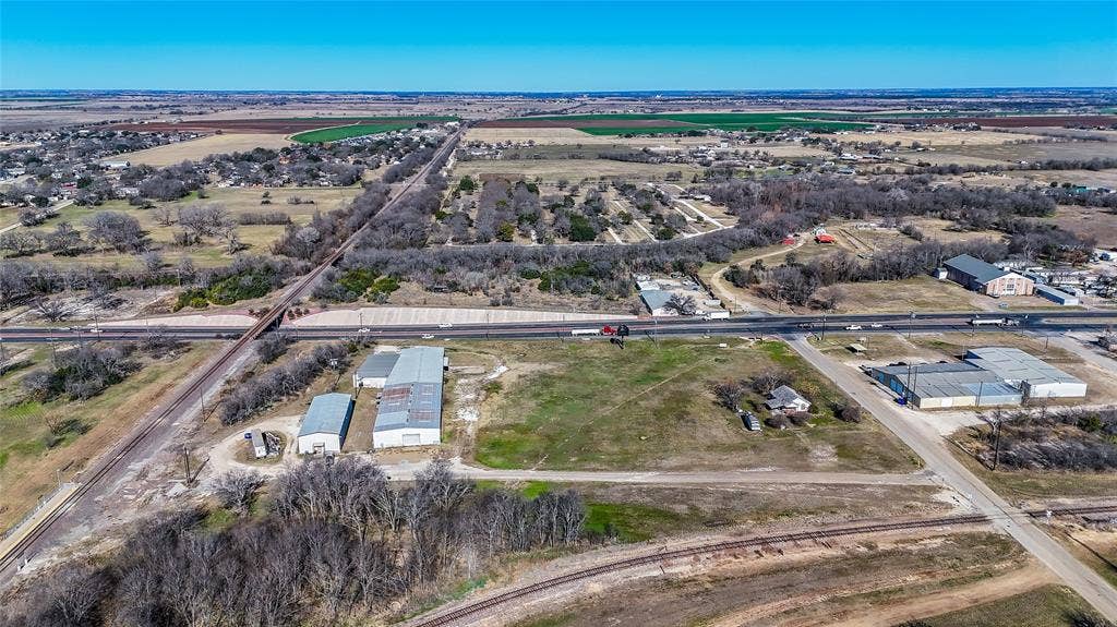 110 1st Street, McGregor, TX 76657 Expansive acreage featuring multiple metal-clad outbuildings, direct road access, and proximity to regional rail lines