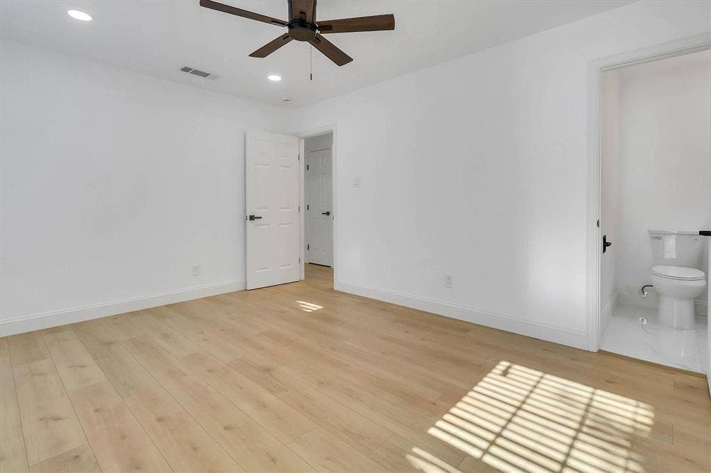 1913 Sandra Kay Lane, Arlington, TX 76015 Room featuring light wood-finish flooring, recessed lighting, a dark-finish ceiling fan, and white doors with matte black hardware, accompanied by a separate restroom with white tile flooring and a porcelain commode