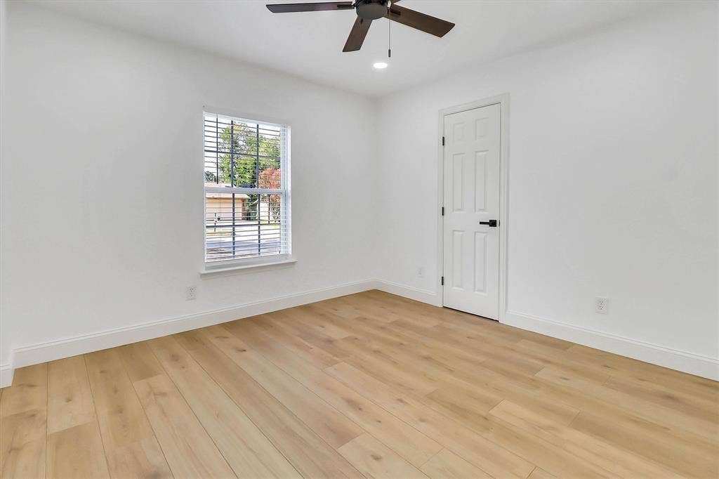 1913 Sandra Kay Lane, Arlington, TX 76015 Light-filled room featuring wood-finish flooring, a ceiling fan, a single-panel interior door with matte black hardware, and a window with white casing