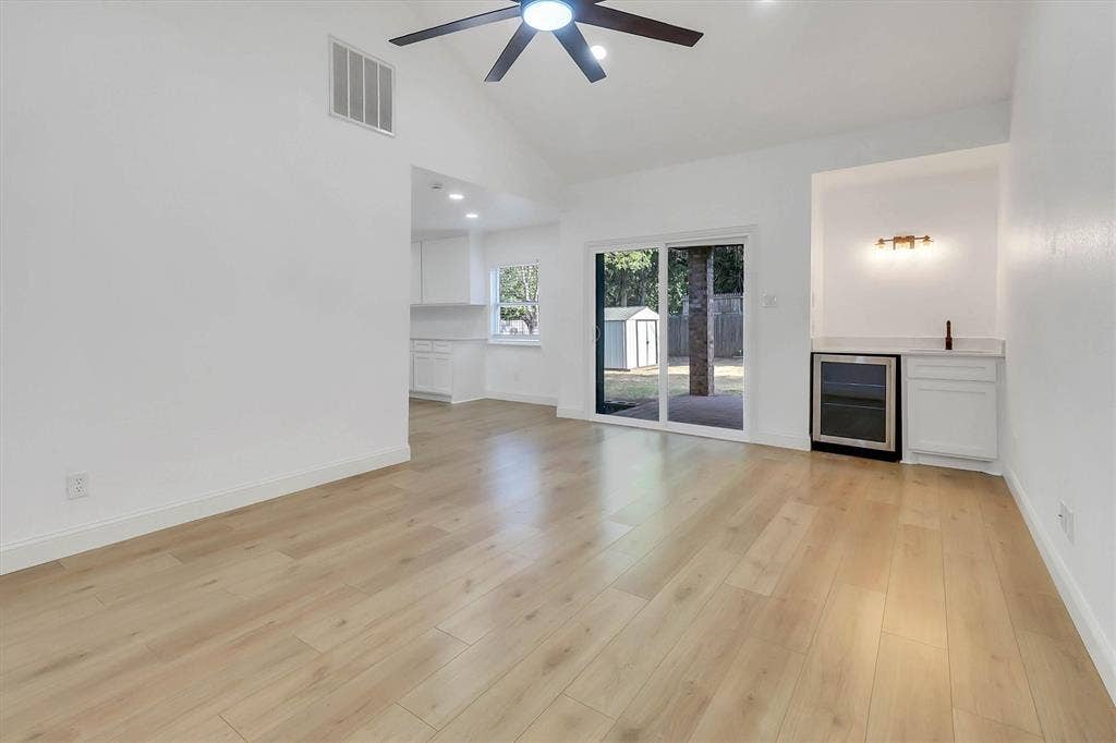 1913 Sandra Kay Lane, Arlington, TX 76015 Vaulted ceiling with integrated ceiling fan, light-toned wood-finish flooring, and built-in wet bar featuring a glass-front beverage refrigerator