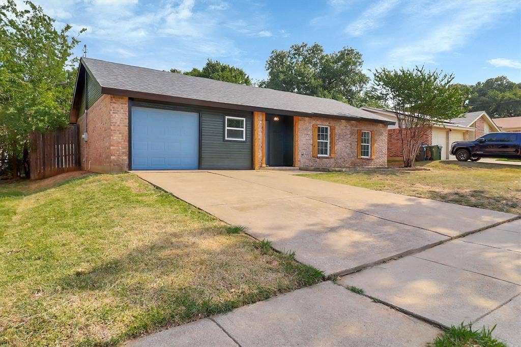 1913 Sandra Kay Lane, Arlington, TX 76015 Single-story residence featuring a brick and horizontal siding exterior, attached garage, concrete driveway, and wood-framed window shutters