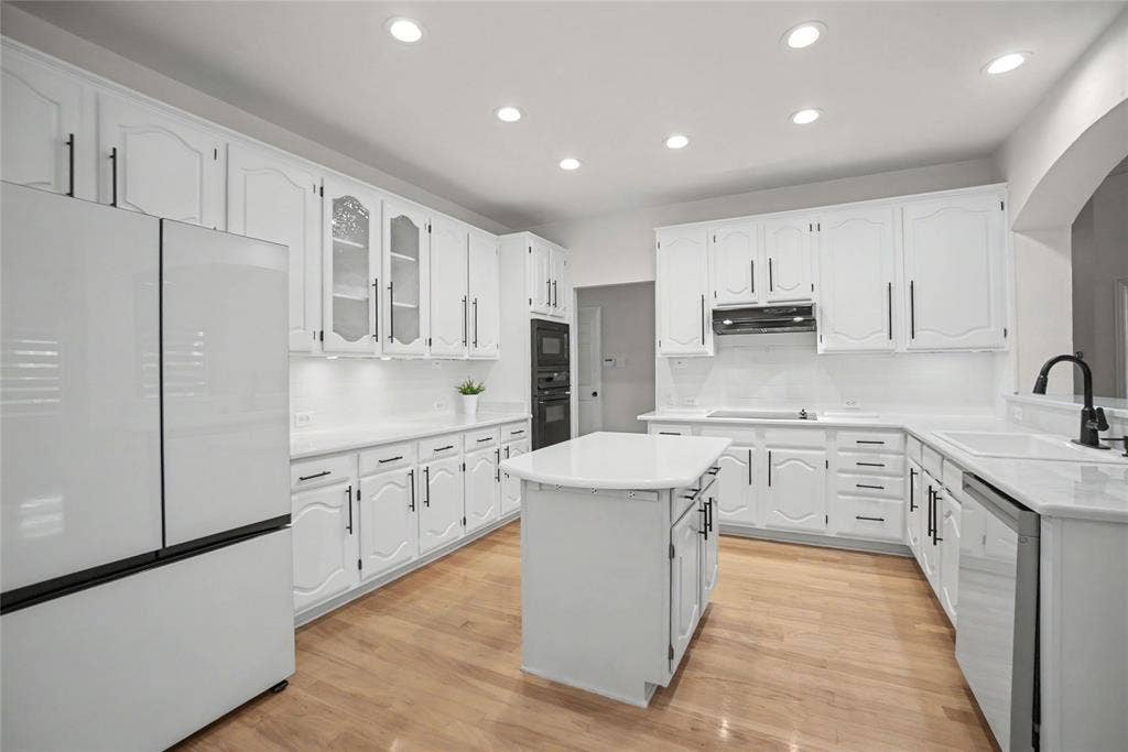 Installed designer quartz counter tops and white subway tile backsplashes. Soft white cabinetry with some glass displays and Black iron hardware. Includes recent Bespoke Refrigerator and Dishwasher.