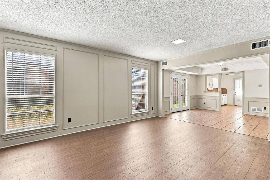 2145 Willow Place, #A, Carrollton, TX 75006 Living area featuring wood-finish flooring, wainscoting, decorative wall molding, large dual-pane windows, and tile flooring