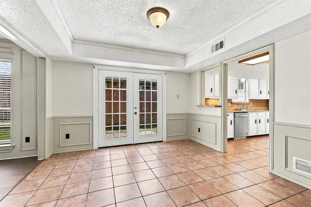 2145 Willow Place, #A, Carrollton, TX 75006 Ceramic tile flooring, full-lite French doors, wainscoting, and a kitchen pass-through window with built-in counter