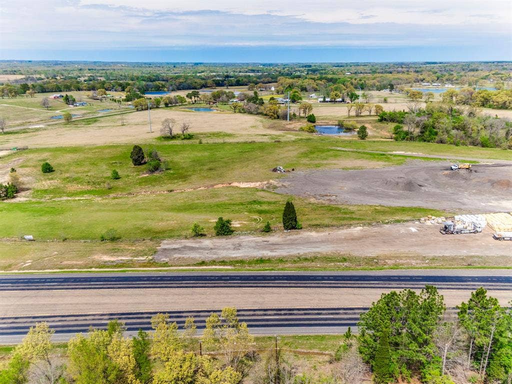 317 Fm 1616, Athens, TX 75752 Expansive acreage featuring cleared land, grassy plains, mature trees, and direct paved road frontage