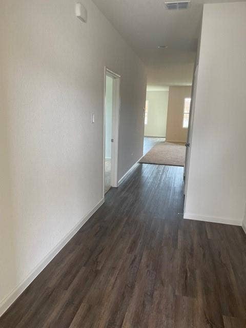 Interior hallway featuring wood-finish flooring, neutral wall tones, and recessed lighting