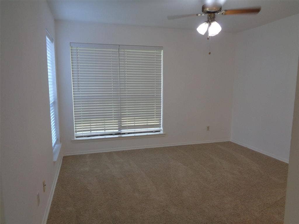 909 Turtle Cove, #141, Irving, TX 75060 Neutral wall finishes, plush carpeting, dual windows with horizontal blinds, and a ceiling-mounted light fixture with fan