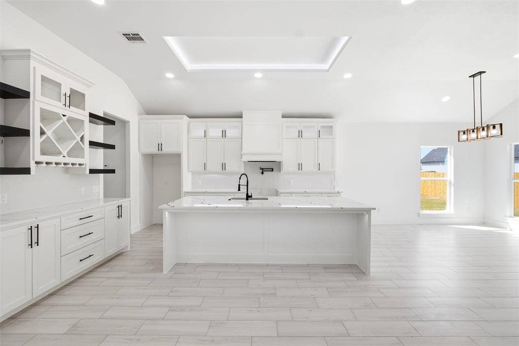 101 Connor Circle, Mabank, TX 75147 Kitchen featuring white cabinetry, center island with stone-finish countertop, built-in wine rack, recessed ceiling lighting, and wood-finish tile flooring