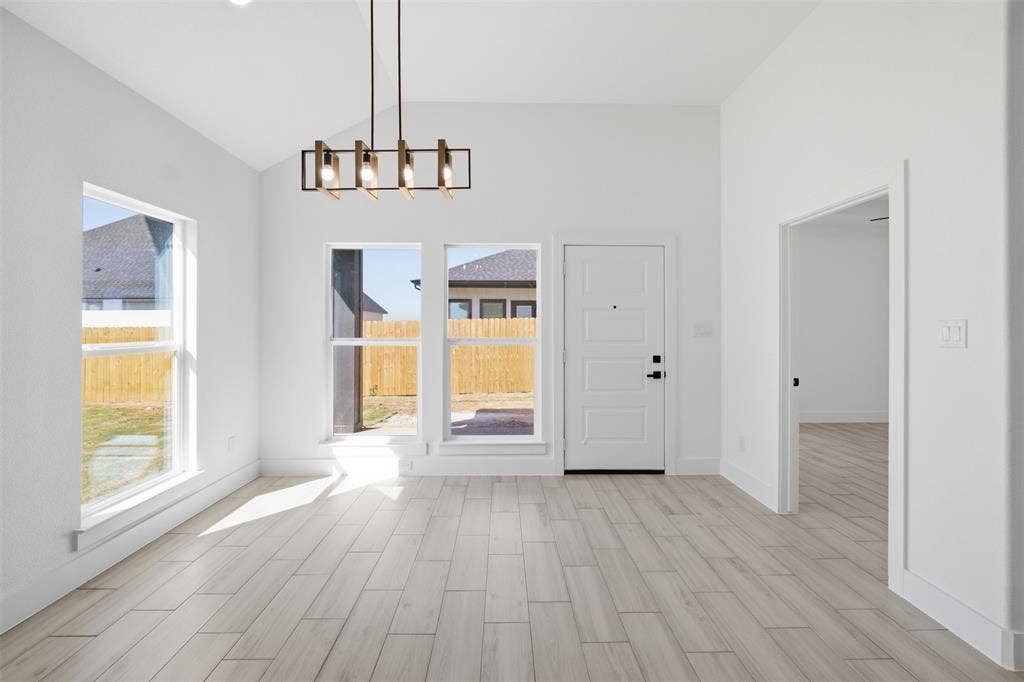 101 Connor Circle, Mabank, TX 75147 Vaulted ceilings, wood-finish tile flooring, geometric iron chandelier, and multiple windows with exterior exposure