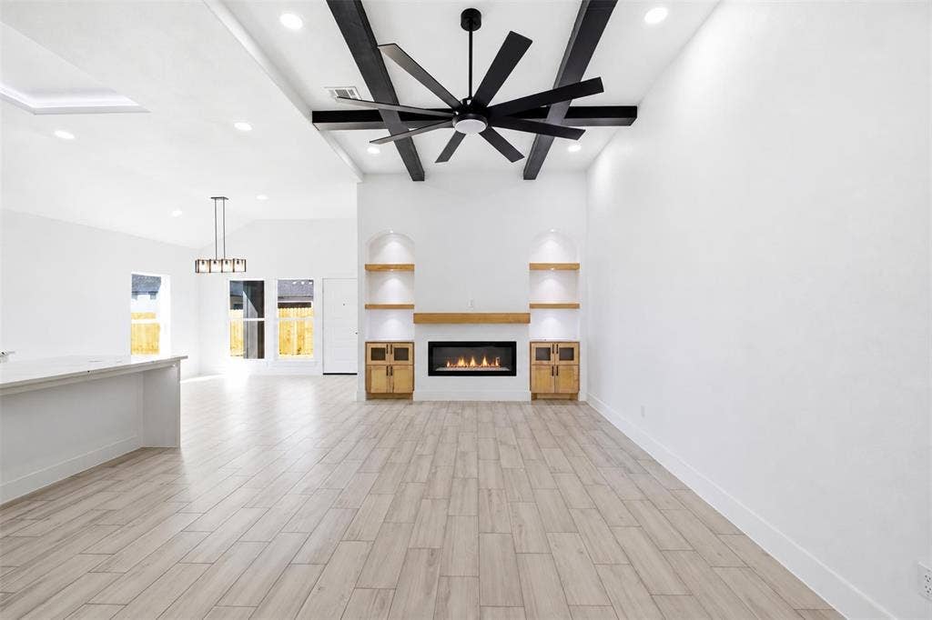 101 Connor Circle, Mabank, TX 75147 Living area featuring wood-finish tile flooring, recessed lighting, ceiling with dark decorative beams and a large ceiling fan, and a fireplace with built-in cabinetry and arched shelving