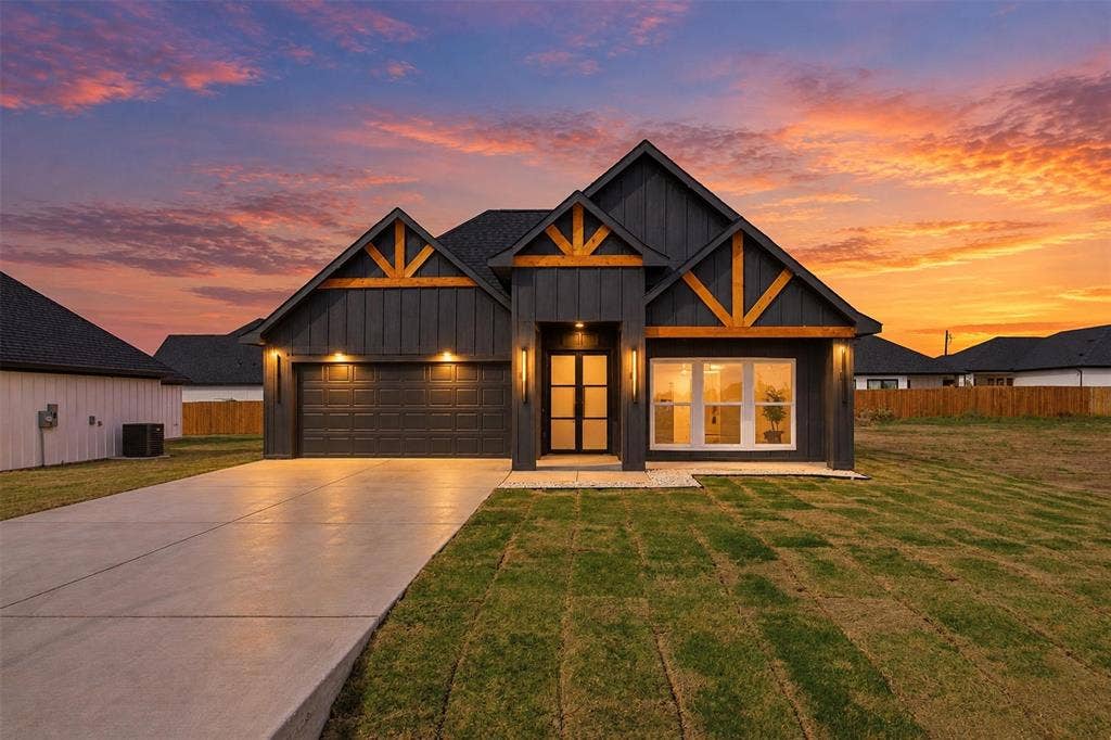 101 Connor Circle, Mabank, TX 75147 Modern exterior featuring dark board-and-batten siding, decorative wood gable accents, a concrete driveway, and a double-door entrance