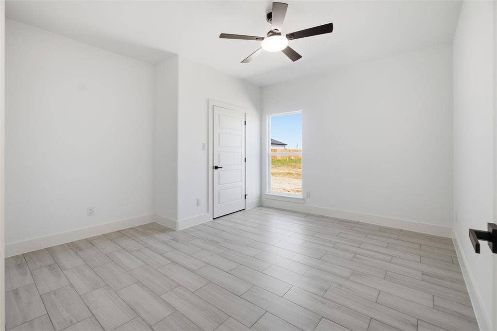 101 Connor Circle, Mabank, TX 75147 Interior space featuring wood-finish flooring, a neutral color palette, a five-panel interior door with matte black hardware, and an integrated ceiling fan with light fixture