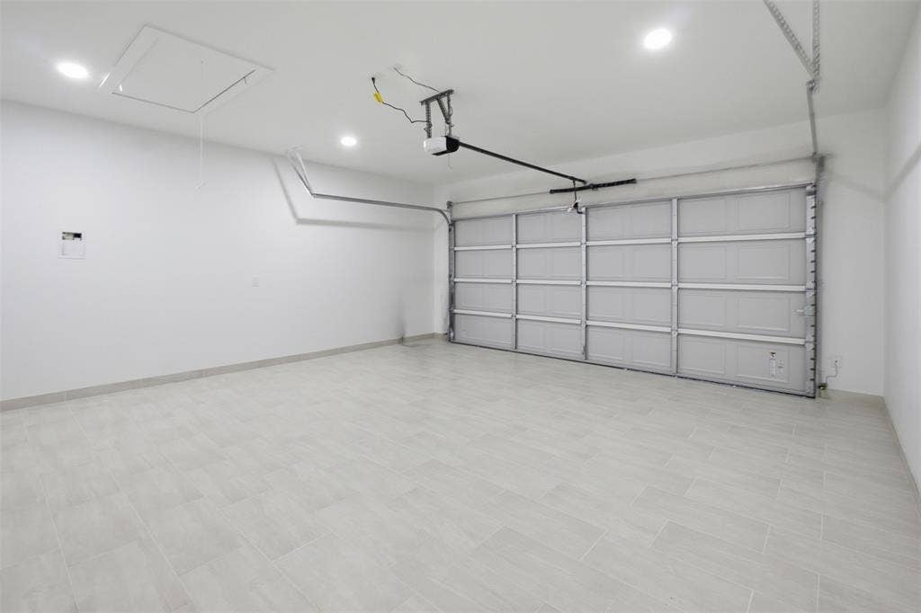 101 Connor Circle, Mabank, TX 75147 Multi-car garage featuring light-toned tile flooring, white walls, recessed ceiling lighting, and an overhead sectional door