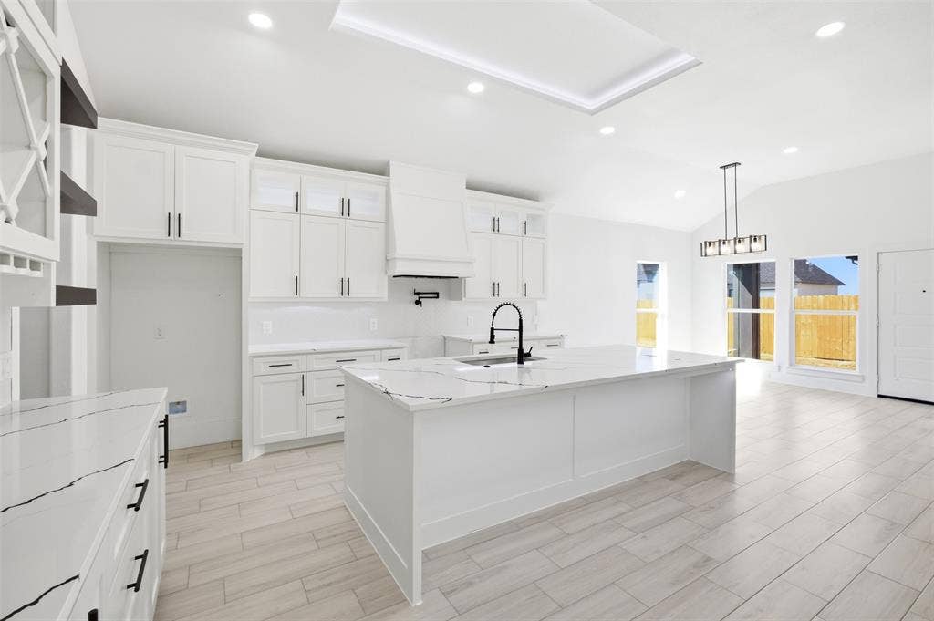 101 Connor Circle, Mabank, TX 75147 Kitchen featuring white shaker cabinetry, an expansive center island with veined stone-style countertops, recessed ceiling lighting, a matte black pot filler, and wood-finish flooring