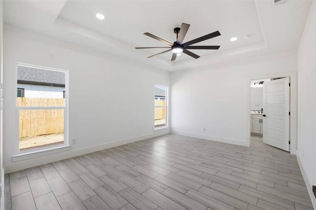 101 Connor Circle, Mabank, TX 75147 Interior space featuring a recessed tray ceiling, multi-blade ceiling fan, recessed lighting, and wood-finish tile flooring