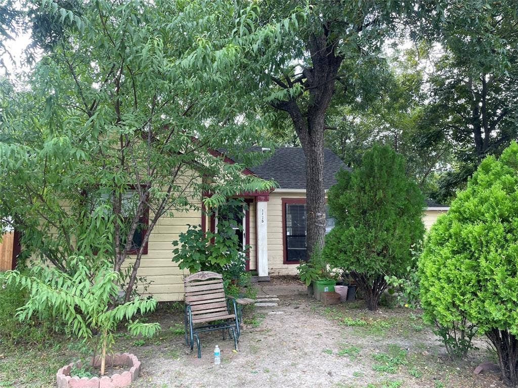 1115 Pine Street, Grand Prairie, TX 75050 Single-story exterior featuring horizontal siding, dark-toned roof shingles, and mature trees