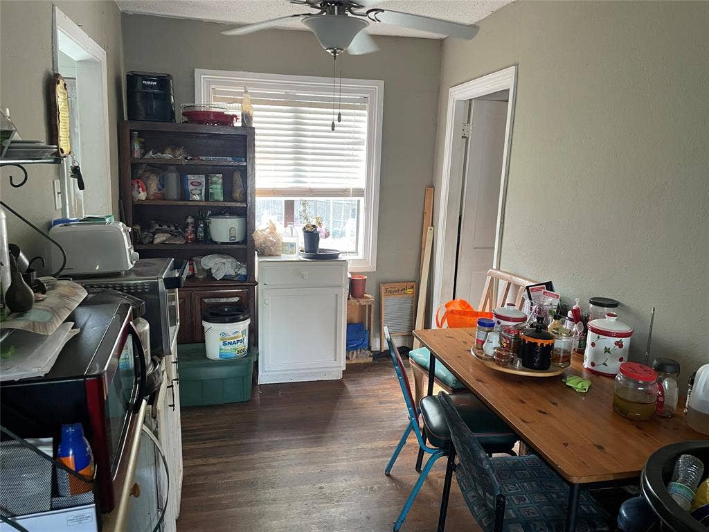 1115 Pine Street, Grand Prairie, TX 75050 Wood-finish flooring, single-pane window with horizontal blinds, and a ceiling-mounted fan