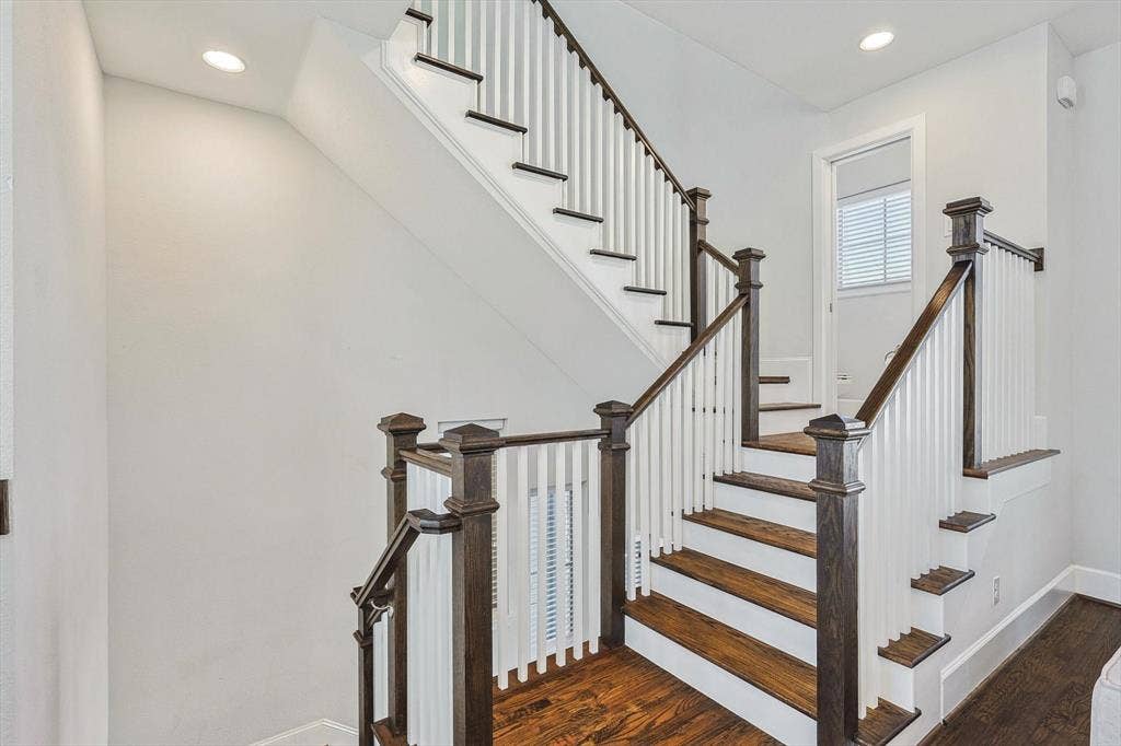 Stairs featuring hardwood / wood-style flooring