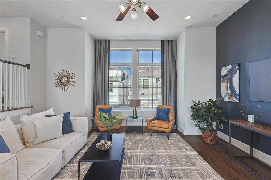 Living room with dark hardwood / wood-style floors and ceiling fan