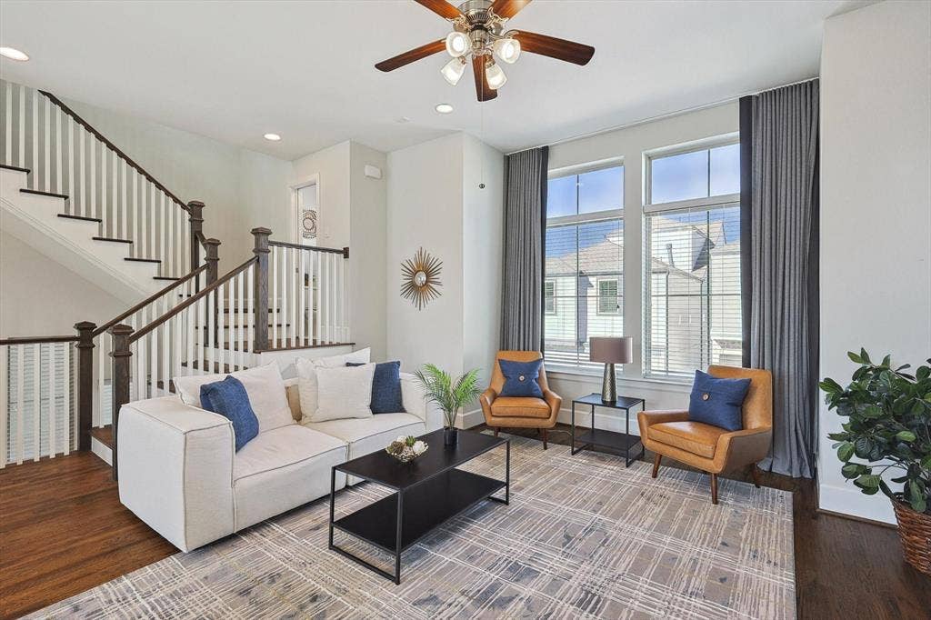 Living room with ceiling fan and hardwood / wood-style flooring