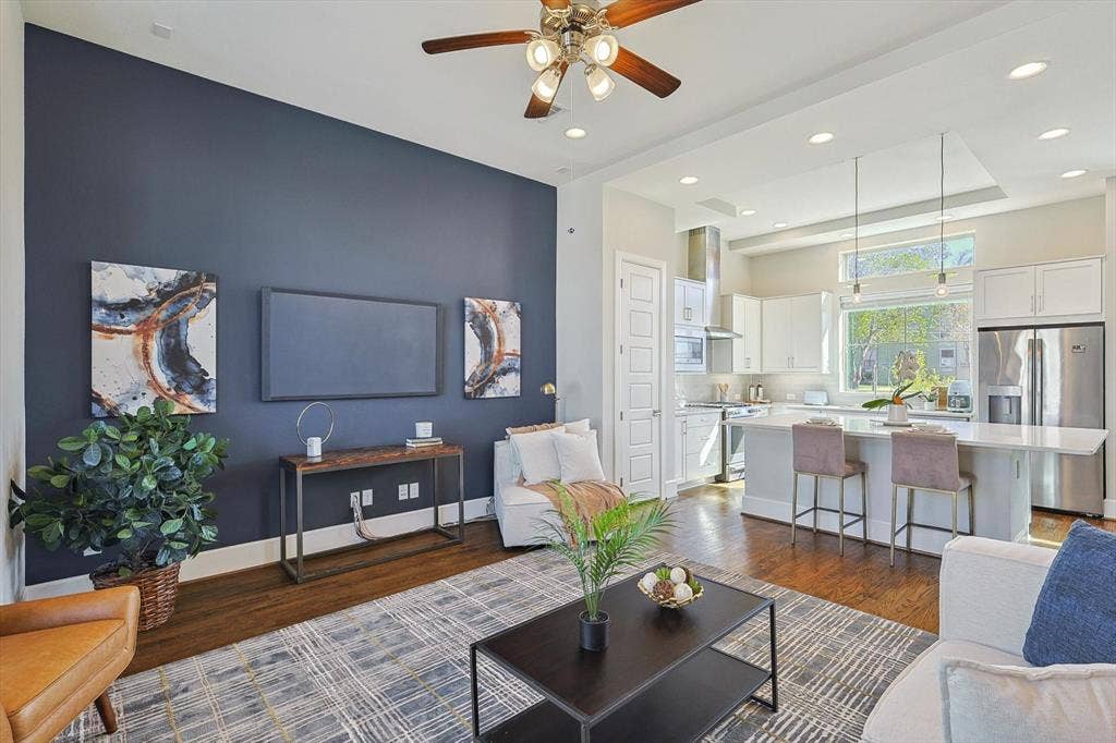 Living room with ceiling fan and dark hardwood / wood-style flooring