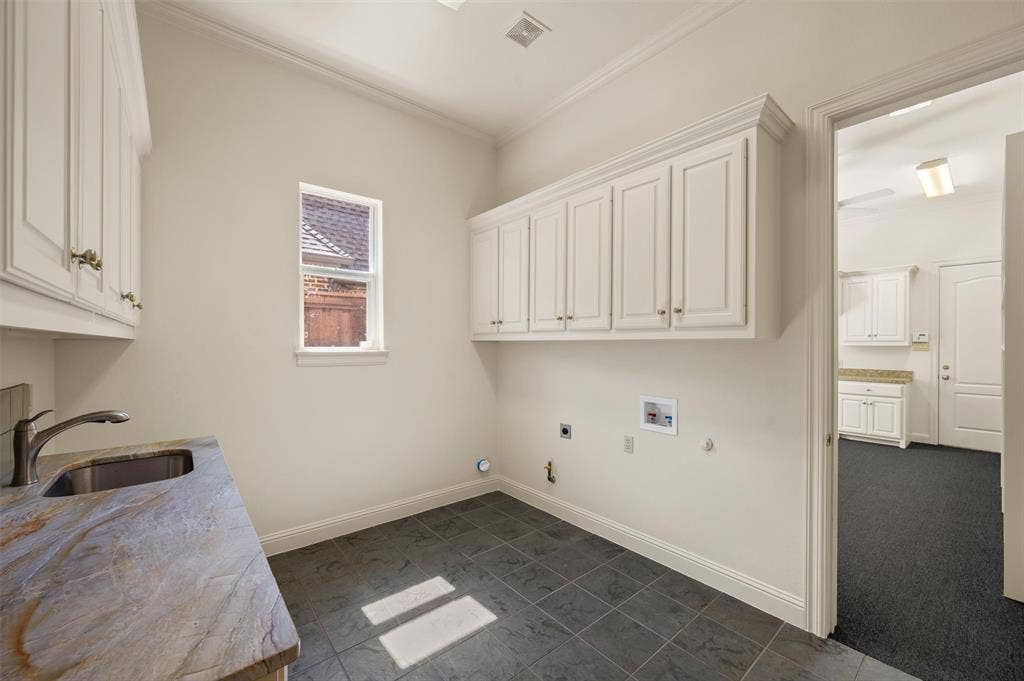 Laundry Room with matching countertops as kitchen, sink and storage.