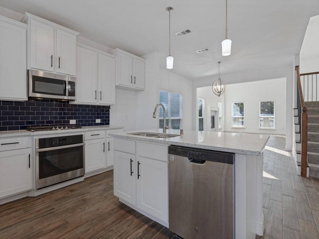 336 Clark Street, Irving, TX 75060 Spacious kitchen with generous cabinet storage, a contrasting tile backsplash, and an open layout.