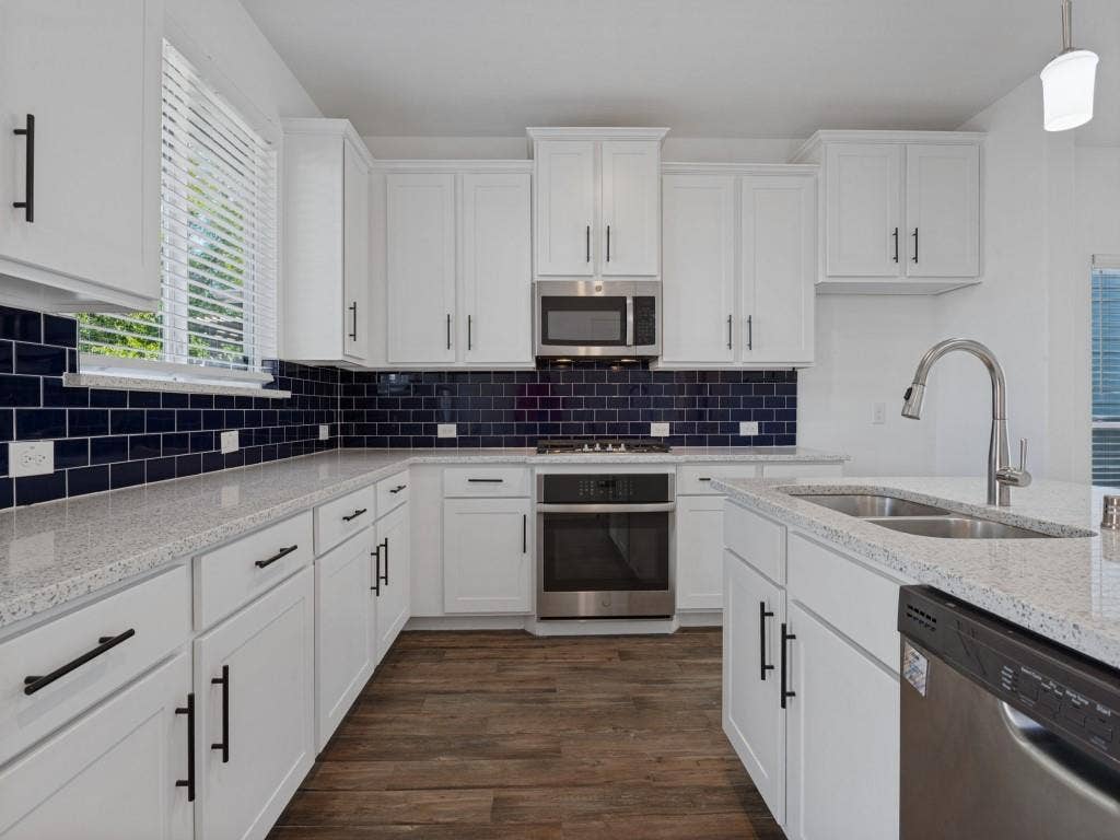 336 Clark Street, Irving, TX 75060 Beautiful kitchen featuring white cabinetry, granite countertops, stainless steel appliances, and a large island