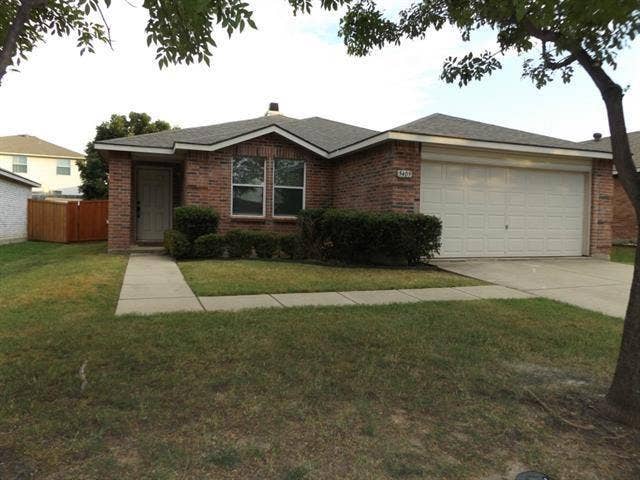 Brick exterior featuring a hip roof, two-car garage, concrete driveway, and front entryway with a covered porch