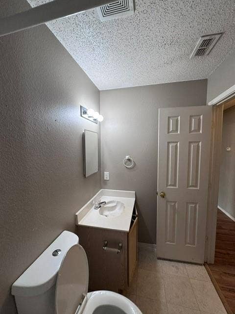 Vanity with integrated sink and countertop, three-light wall fixture, and six-panel interior door