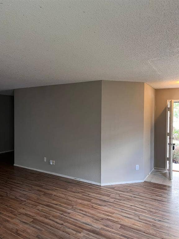 Interior space featuring wood-finish flooring, textured ceiling, and neutral-toned wall paint
