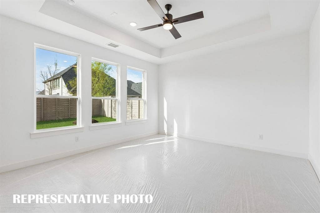 Located at the rear of the home for additional privacy, this dream owner's suite features high ceilings, a wall of windows overlooking the back yard and plush carpeting.  REPRESENTATIVE PHOTO