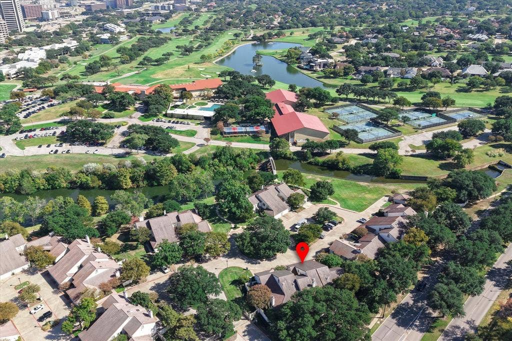 4611 O Connor Court, Irving, TX 75062 Aerial perspective of a multi-unit residential complex featuring gabled rooflines, mature shade trees, and proximity to a waterway and public recreational facilities