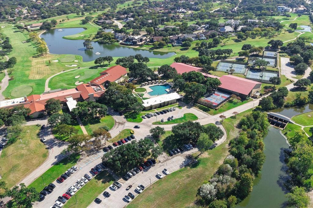 4611 O Connor Court, Irving, TX 75062 Aerial view of a sprawling complex featuring multiple swimming pools, tennis courts, red-tile roofing, and expansive grounds situated along a water feature and golf course