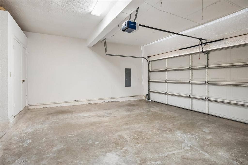 4611 O Connor Court, Irving, TX 75062 Multi-car garage featuring a sectional overhead door, concrete flooring, and an integrated garage door opener