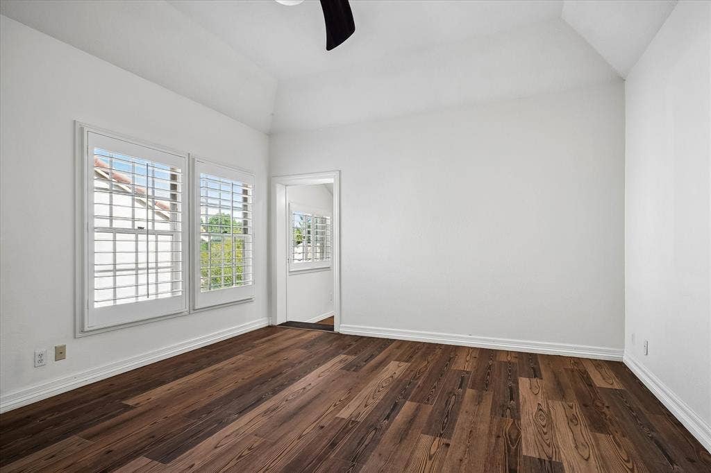 4611 O Connor Court, Irving, TX 75062 Vaulted ceiling featuring a central ceiling fan, VLP flooring, and windows with plantation shutters