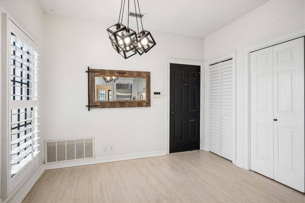4611 O Connor Court, Irving, TX 75062 Geometric multi-light pendant fixture, white plantation shutters, wood-finish flooring, and crisp white panel doors